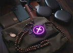 Necklace with a glowing purple cross  pendant on a leather surface tactle faith